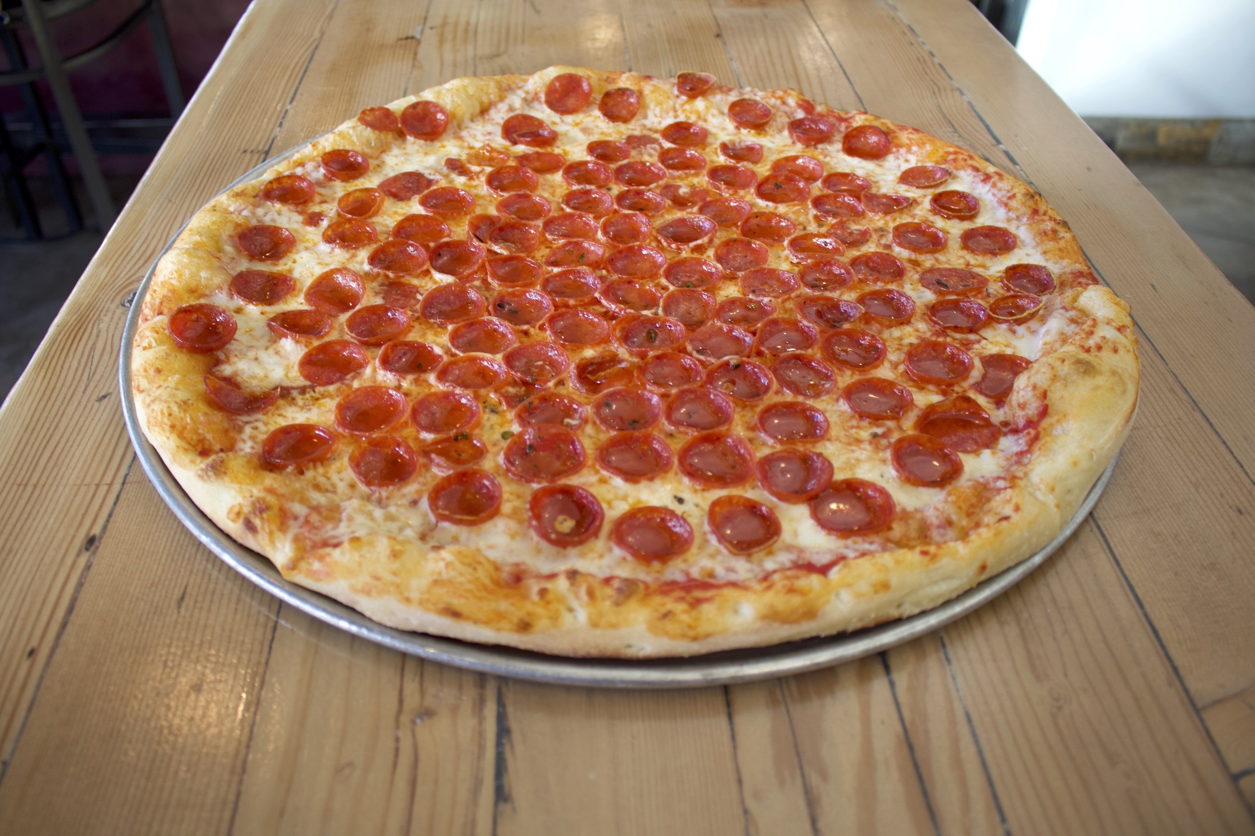 A HomeSlice pepperoni pizza on a table, ready to share