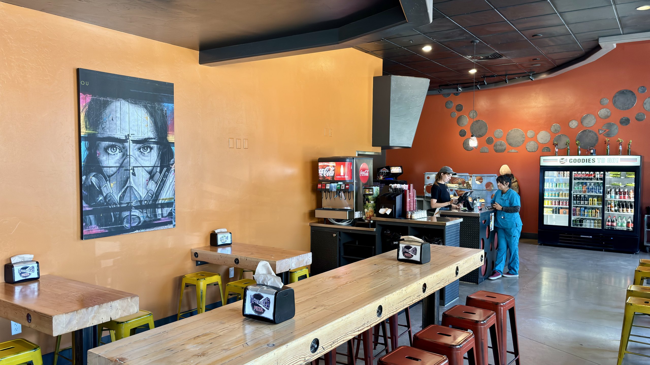 The pizza-pan wall art in the dining room at HomeSlice Pizza Three Springs